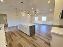Open-concept kitchen featuring a center island, white cabinets and modern pendant lighting at 350 N Florence St, Florence, AZ 85132