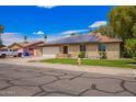 Well-maintained home featuring a green lawn and energy-efficient solar panels on the roof at 3556 E Angela Dr, Phoenix, AZ 85032