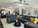Spacious living room featuring a large sectional sofa, ceiling fan, and decor accents at 3806 N 80Th Dr, Phoenix, AZ 85033