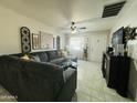 Comfortable living room featuring a large sectional sofa, ceiling fan, and door to the exterior at 3806 N 80Th Dr, Phoenix, AZ 85033