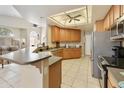 Well-lit kitchen with wood cabinets, stainless steel appliances, tile floors, and ample counter space at 4202 E Broadway Rd # 40, Mesa, AZ 85206