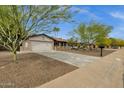 Inviting single-Gathering home features a spacious driveway, attached garage, and low-maintenance desert landscaping at 4840 E Sunnyside Dr, Scottsdale, AZ 85254