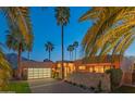 Contemporary home exterior showcasing a gated entrance, desert landscaping, and a well-lit driveway at 5434 E Lincoln Dr # 58, Paradise Valley, AZ 85253