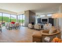 Spacious living room featuring a modern fireplace, floor-to-ceiling windows, and open dining area at 5434 E Lincoln Dr # 58, Paradise Valley, AZ 85253