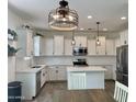 Modern kitchen boasting white cabinets, stainless steel appliances, and a stylish center island at 5549 S Dillon --, Mesa, AZ 85212
