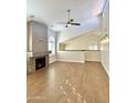 Bright living room features wood floors, arched windows, a ceiling fan, and a cozy fireplace at 5640 E Bell Rd # 1098, Scottsdale, AZ 85254