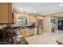 Spacious kitchen with stainless steel refrigerator, wood cabinets, and granite countertops at 6611 E Voltaire Ave, Scottsdale, AZ 85254