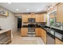Well-lit kitchen with wood cabinets, granite countertops, stainless steel appliances, and tile flooring at 6611 E Voltaire Ave, Scottsdale, AZ 85254
