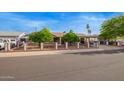 Charming single story home featuring an enclosed front yard, mature trees, and covered carport at 7423 E Cambridge Ave, Scottsdale, AZ 85257
