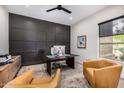 Modern home office featuring a dark paneled wall and lots of natural light at 9627 E Adobe Dr, Scottsdale, AZ 85255