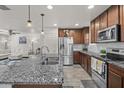 Bright and open kitchen featuring granite countertops, stainless steel appliances, and an island with bar seating overlooking the living area at 1317 N Balboa --, Mesa, AZ 85205