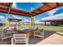 Inviting outdoor lounge area with comfortable seating around a fire pit and pergola at 13254 E Verbina Ln, Florence, AZ 85132