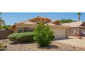 Charming single-story home with a well-maintained front yard, desert landscaping, and a two-car garage at 13421 W Ocotillo Ln, Surprise, AZ 85374