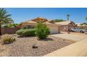 Charming single-story home with a well-maintained front yard, desert landscaping, and a two-car garage at 13421 W Ocotillo Ln, Surprise, AZ 85374