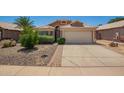 Charming single-story home with a well-maintained front yard, desert landscaping, and a two-car garage at 13421 W Ocotillo Ln, Surprise, AZ 85374