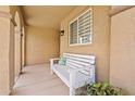 Inviting covered front porch with a white bench and decorative potted plants at 1462 E Poncho Ln, San Tan Valley, AZ 85143