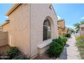 Exterior view of the house showcases a beige stucco wall and desert landscaping along the sidewalk at 16017 N 19Th Dr, Phoenix, AZ 85023
