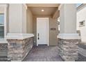Inviting covered entryway with stone accents leading to a bright white front door at 1913 W Lariat Ln, Phoenix, AZ 85085