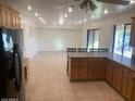 Open concept kitchen with wood cabinets, tiled floors, and a view to the living area with a sliding glass door at 207 E Papago Dr, Tempe, AZ 85288