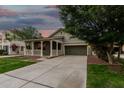 Cozy single-story home with a charming front porch and a long driveway at dusk at 20866 W Hamilton St, Buckeye, AZ 85396