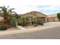 Single-story home with a desert landscaped yard, gated front porch, and two car garage at 2585 E Carob Dr, Gilbert, AZ 85298