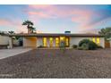 Exterior dusk shot of a quaint home showcasing desert landscaping, covered parking, and a welcoming facade at 845 E Village Circle S Dr, Phoenix, AZ 85022