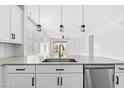 Bright kitchen featuring stainless steel sink and appliances, quartz countertops, and backyard views at 9728 E Twinkle Ave, Mesa, AZ 85212