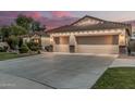 Three-car garage with carriage doors and stone accents, complemented by desert landscaping at 11511 E Chestnut Ct, Chandler, AZ 85249
