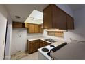 Compact kitchen with dated appliances, wood cabinets, and a window boarded up with plywood at 12231 N 22Nd Ave, Phoenix, AZ 85029