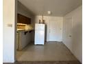 Compact kitchen with essential appliances, tile flooring, and simple cabinetry at 12231 N 22Nd Ave, Phoenix, AZ 85029