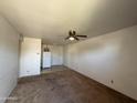 Empty living room featuring a ceiling fan, access to the kitchen, and neutral walls at 12231 N 22Nd Ave, Phoenix, AZ 85029