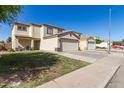 Residential street featuring a two-story home with a two-car garage and sidewalk at 12430 W Scotts Dr, El Mirage, AZ 85335