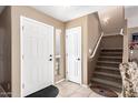Inviting foyer featuring tile flooring, staircase, and front door with sidelight at 12430 W Scotts Dr, El Mirage, AZ 85335