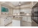 Bright kitchen features white cabinetry, granite countertops, a center island, and stainless steel appliances at 16014 S 13Th Way, Phoenix, AZ 85048