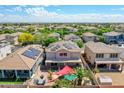 Aerial shot of a home featuring a vibrant backyard oasis with pool, palm trees, a covered patio, and solar panels at 16322 N 171St Dr, Surprise, AZ 85388