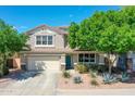 Charming two-story home with landscaped yard, desert plants, a two-car garage, and a welcoming entrance at 16322 N 171St Dr, Surprise, AZ 85388