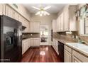 Well-lit kitchen featuring granite countertops, black appliances, and rich wood flooring at 1700 E Lakeside Dr # 64, Gilbert, AZ 85234