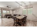 Open living area with wood-look tile flooring, a cozy couch, and abundant natural light at 17219 W Gibson Ln, Goodyear, AZ 85338