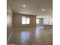 Open-concept living room with tile flooring, recessed lighting, and abundant natural light from large windows at 17482 W Fulton St, Goodyear, AZ 85338