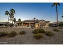 Desert backyard with mature landscaping, covered patio and golf course views at 19541 N Rim Dr, Surprise, AZ 85374