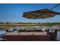 Covered patio with comfortable seating and a beautiful golf course view with outdoor fireplace at 19541 N Rim Dr, Surprise, AZ 85374