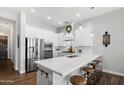 Bright kitchen featuring white cabinets, stainless steel appliances, and a spacious island with seating at 20607 W Point Ridge Rd, Buckeye, AZ 85396
