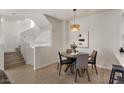 Bright dining area with modern light fixture adjacent to a staircase and a kitchen with a breakfast bar at 2315 N 52Nd St # 102, Phoenix, AZ 85008