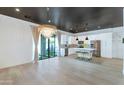 Bright open-concept with wood floors, modern light fixture, a kitchen island and stainless appliances enhance this space at 3136 E Cheryl Dr, Phoenix, AZ 85028