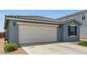 Two-car garage and desert landscape surrounding a well-maintained exterior at 36463 W San Alvarez Ave, Maricopa, AZ 85138