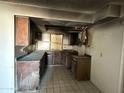 Damaged kitchen with cabinets, counters, and fire damage at 3719 W Thunderbird Rd, Phoenix, AZ 85053