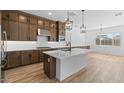 Modern kitchen with island, stainless steel appliances, tile backsplash, and stylish pendant lights at 37627 W Padilla St, Maricopa, AZ 85138