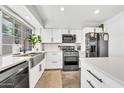 Modern kitchen with stainless steel appliances, white cabinets, and a farmhouse sink at 4208 N Parkway Ave, Scottsdale, AZ 85251