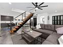 Bright living room featuring a gray sectional sofa, floating stairs, and modern decor at 4208 N Parkway Ave, Scottsdale, AZ 85251