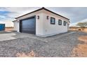 Detached garage featuring a modern black door and paver accents at 43481 W Carefree Pl, Maricopa, AZ 85138